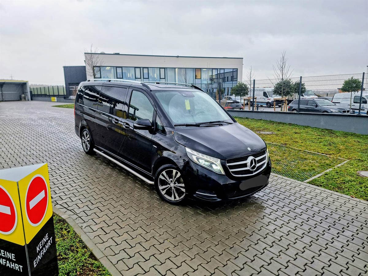Crni Mercedes kombi za transfer parkiran ispred poslovnog objekta